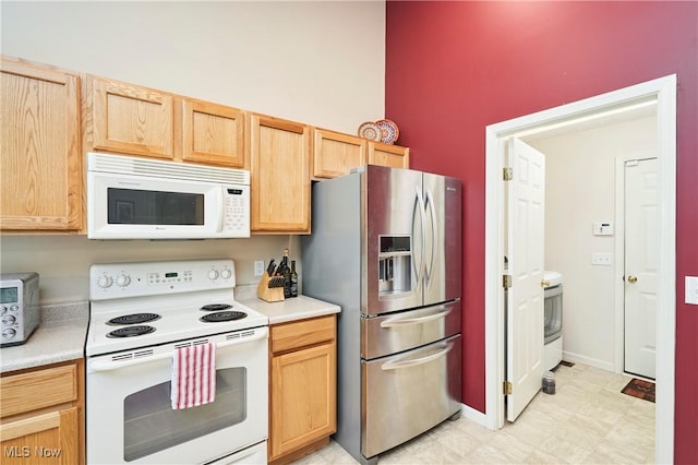 1917 Northgate Cir, Akron, OH 44320 - kitchen featuring white appliances, light countertops, a high ceiling, light brown cabinetry, and baseboards