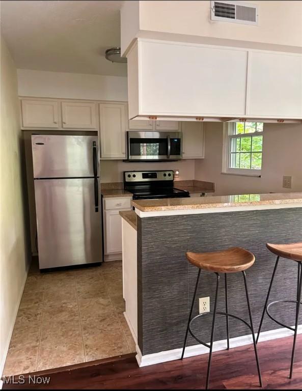 1808 Stoney Run Cir, Broadview Heights, OH 44147 - kitchen with stainless steel appliances, a kitchen breakfast bar, and white cabinets