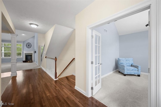 4819 Trails End Ct, Westlake, OH 44145 - corridor featuring ornate columns, vaulted ceiling, wood finished floors, an upstairs landing, and baseboards