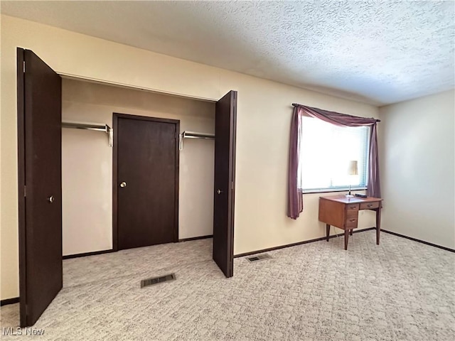 547 Towns Ln Unit 129, Richmond Heights, OH 44143 - unfurnished bedroom featuring light colored carpet, a textured ceiling, baseboards, and a closet