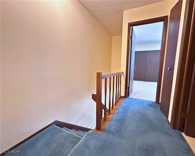 547 Towns Ln Unit 129, Richmond Heights, OH 44143 - corridor featuring an upstairs landing, a textured ceiling, carpet floors, and baseboards