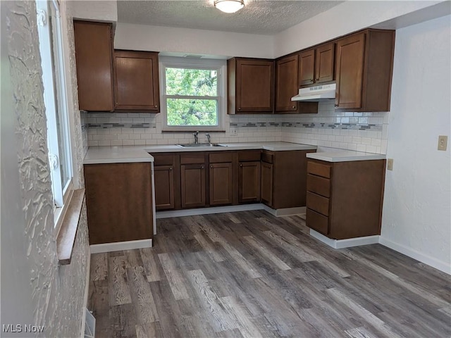 871 Chinook Ave, Akron, OH 44305 - kitchen featuring under cabinet range hood, backsplash, dark wood-style floors, a sink, and a textured ceiling