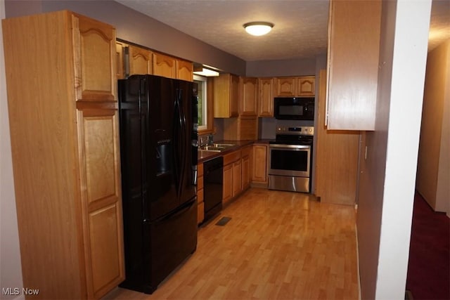 1259 Cherry Ln, Brunswick, OH 44212 - kitchen featuring black appliances, light wood finished floors, dark countertops, and a sink