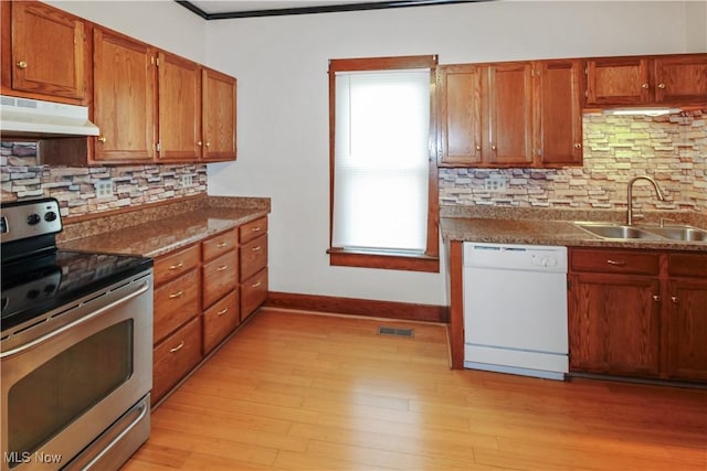 1515 E 3rd St, Port Clinton, OH 43452 - kitchen with electric range, white dishwasher, under cabinet range hood, a sink, and backsplash
