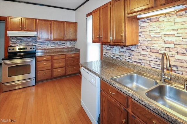 1515 E 3rd St, Port Clinton, OH 43452 - kitchen with electric range, white dishwasher, under cabinet range hood, a sink, and brown cabinetry