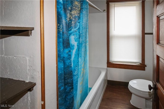 1515 E 3rd St, Port Clinton, OH 43452 - bathroom featuring wood finished floors, toilet, shower / tub combo with curtain, and baseboards