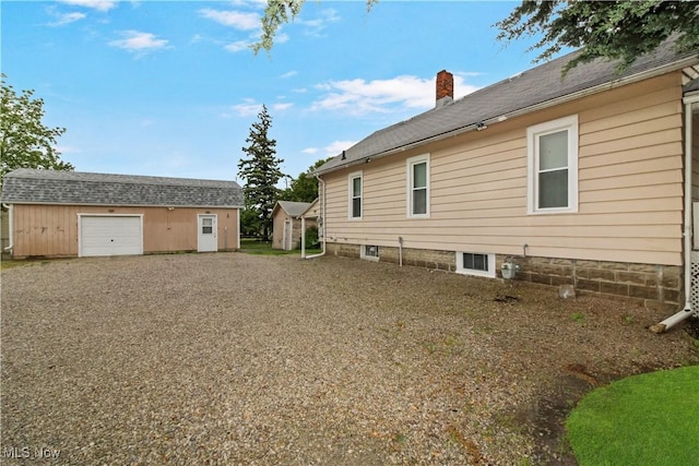 1515 E 3rd St, Port Clinton, OH 43452 - view of home's exterior featuring a chimney, an outdoor structure, and a garage