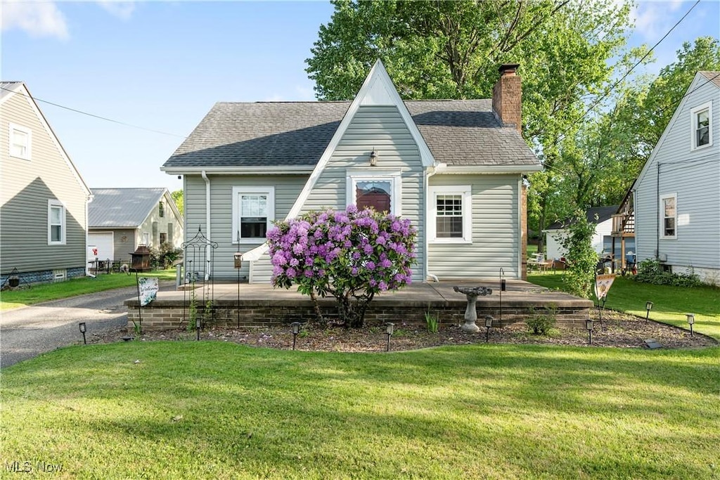 261 Jacob St NE, Navarre, OH 44662 - view of front of property with a chimney, a shingled roof, and a front yard