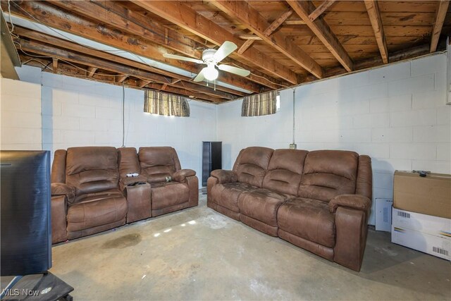 1923 15th St SW, Akron, OH 44314 - living room with concrete floors, concrete block wall, and ceiling fan