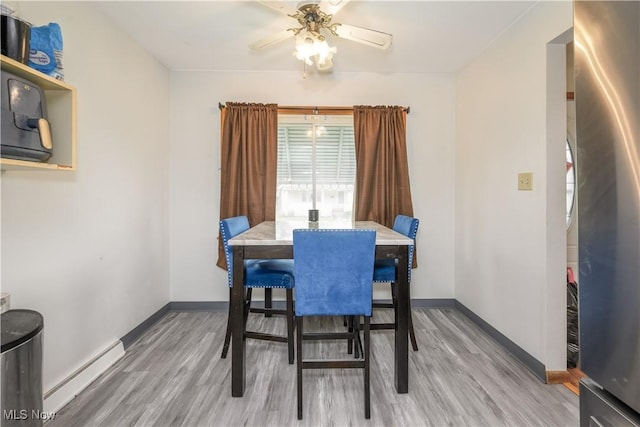 1923 15th St SW, Akron, OH 44314 - dining space with a baseboard heating unit, wood finished floors, baseboards, and a ceiling fan