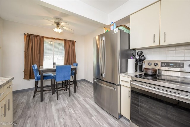1923 15th St SW, Akron, OH 44314 - kitchen featuring stainless steel appliances, light countertops, ceiling fan, tasteful backsplash, and light wood-type flooring