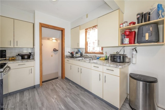 1923 15th St SW, Akron, OH 44314 - kitchen with backsplash, light countertops, light wood finished floors, and stainless steel microwave