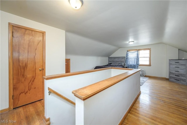 1923 15th St SW, Akron, OH 44314 - corridor featuring an upstairs landing, light wood-style flooring, vaulted ceiling, and baseboards