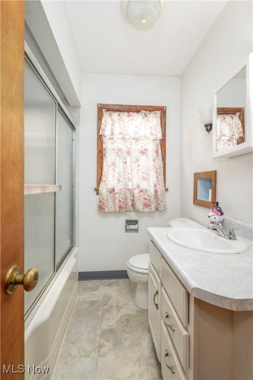 1923 15th St SW, Akron, OH 44314 - bathroom with vanity, toilet, baseboards, and bath / shower combo with glass door