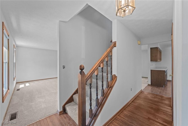 7124 Hollyhock Ln, Solon, OH 44139 - stairway with wood finished floors, baseboards, and a chandelier