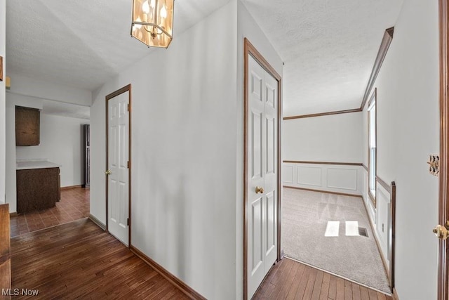 7124 Hollyhock Ln, Solon, OH 44139 - corridor featuring hardwood / wood-style floors, a textured ceiling, and a chandelier