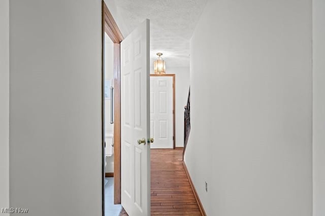 7124 Hollyhock Ln, Solon, OH 44139 - hallway with wood finished floors, a chandelier, a textured ceiling, and baseboards