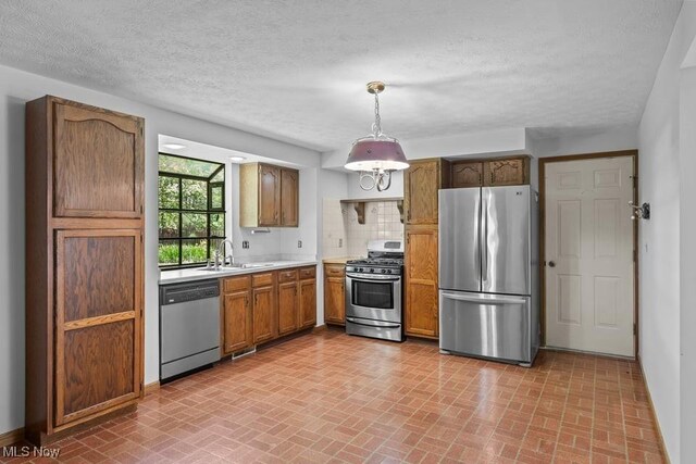 7124 Hollyhock Ln, Solon, OH 44139 - kitchen featuring appliances with stainless steel finishes, brick patterned flooring, a sink, light countertops, and a textured ceiling