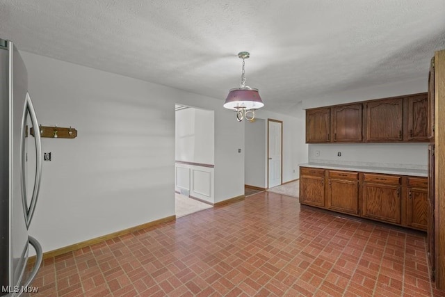 7124 Hollyhock Ln, Solon, OH 44139 - kitchen with freestanding refrigerator, brick patterned floors, baseboards, light countertops, and hanging light fixtures