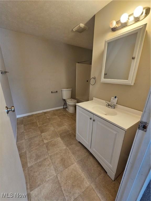 2889 State Route 46 S, Jefferson, OH 44047 - bathroom featuring vanity, toilet, a textured ceiling, and baseboards