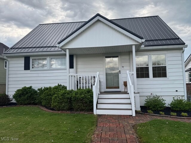 1505 N 14th St, Cambridge, OH 43725 - view of front facade with covered porch, metal roof, and a front yard
