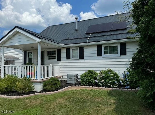 1505 N 14th St, Cambridge, OH 43725 - back of house featuring covered porch, solar panels, central AC, and a lawn