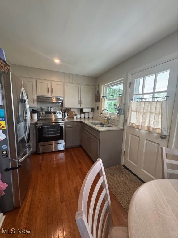 1505 N 14th St, Cambridge, OH 43725 - kitchen with stainless steel appliances, a sink, under cabinet range hood, light countertops, and dark wood-style floors