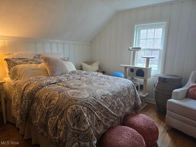 1505 N 14th St, Cambridge, OH 43725 - bedroom featuring wood-type flooring, lofted ceiling, and a decorative wall