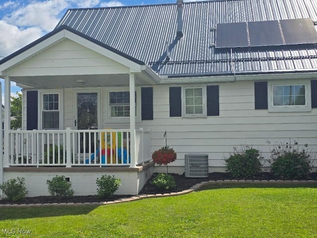 1505 N 14th St, Cambridge, OH 43725 - view of front of property featuring central air condition unit, covered porch, a front lawn, and metal roof
