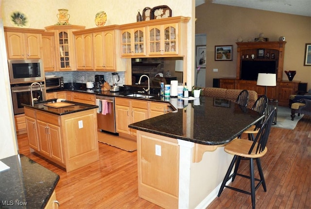 7711 Marewood Pl, Painesville, OH 44077 - kitchen featuring stainless steel appliances, a sink, light wood finished floors, open floor plan, and high vaulted ceiling