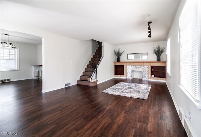 3525 Raymont Rd, University Heights, OH 44118 - unfurnished living room featuring wood finished floors, a tiled fireplace, baseboards, and stairway