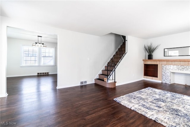 3525 Raymont Rd, University Heights, OH 44118 - unfurnished living room with a chandelier, stairway, a tile fireplace, wood finished floors, and baseboards