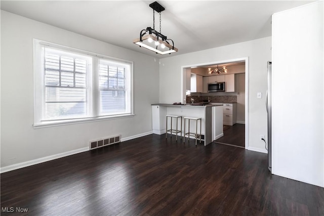3525 Raymont Rd, University Heights, OH 44118 - dining area featuring a chandelier, dark wood-type flooring, and baseboards