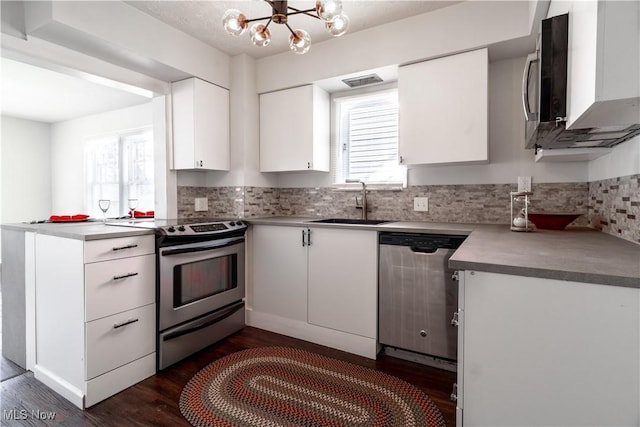 3525 Raymont Rd, University Heights, OH 44118 - kitchen with appliances with stainless steel finishes, a sink, a chandelier, decorative backsplash, and dark wood-style floors