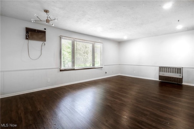3525 Raymont Rd, University Heights, OH 44118 - spare room with wood finished floors, an AC wall unit, a chandelier, radiator, and a textured ceiling