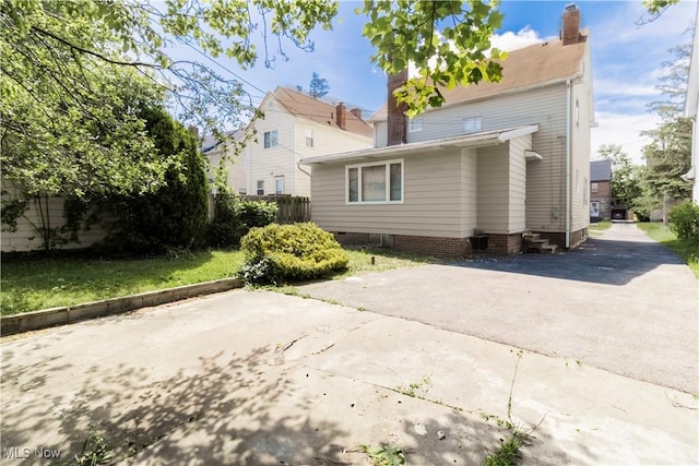 3525 Raymont Rd, University Heights, OH 44118 - back of property with a chimney, a patio area, and driveway
