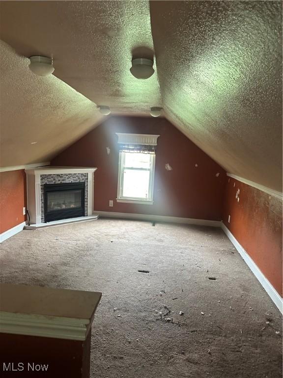 231 Pine St, Weirton, WV 26062 - bonus room featuring a textured ceiling, carpet flooring, baseboards, lofted ceiling, and a tiled fireplace