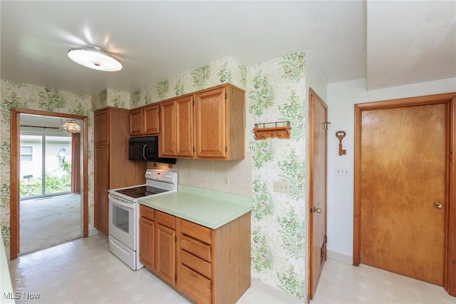 144 Charlotte St, Painesville, OH 44077 - kitchen with white range with electric cooktop, black microwave, wallpapered walls, light floors, and light countertops