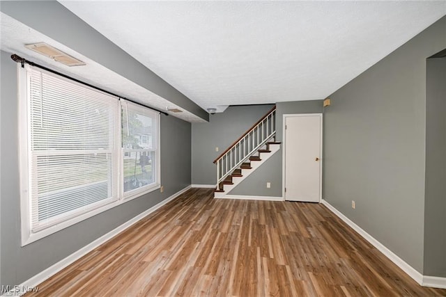 625 Canterbury Ln, Medina, OH 44256 - unfurnished living room with baseboards, stairway, and wood finished floors