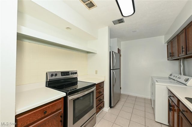 625 Canterbury Ln, Medina, OH 44256 - kitchen with appliances with stainless steel finishes, washer and dryer, light countertops, light tile patterned flooring, and backsplash