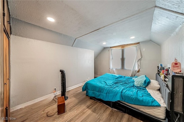 5100 Greenhurst Dr, Maple Heights, OH 44137 - bedroom with wood finished floors, vaulted ceiling, baseboards, a textured ceiling, and recessed lighting