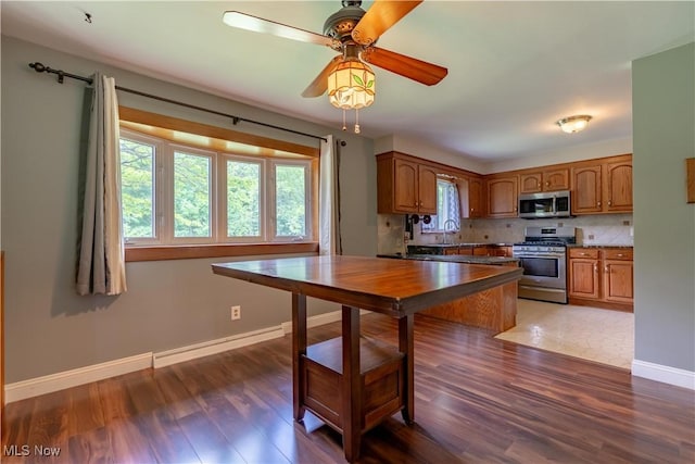 731 39th St SW, Canton, OH 44706 - kitchen with stainless steel appliances, brown cabinets, plenty of natural light, and baseboards