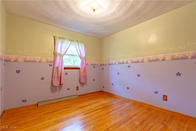 731 39th St SW, Canton, OH 44706 - empty room with a baseboard radiator, light wood finished floors, and baseboards