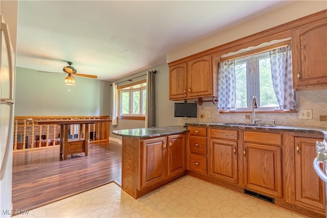 731 39th St SW, Canton, OH 44706 - kitchen featuring a sink, brown cabinets, and a peninsula