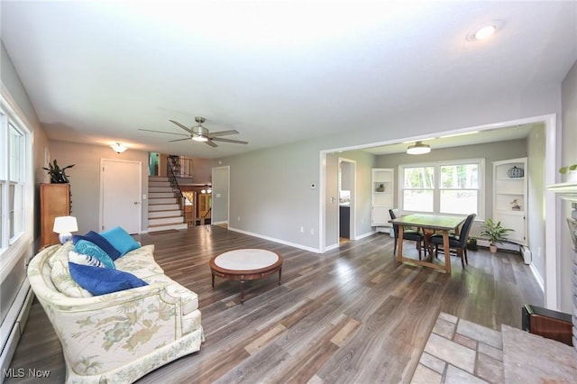 12274 Kile Rd, Chardon, OH 44024 - living area with stairway, a ceiling fan, wood finished floors, and baseboard heating