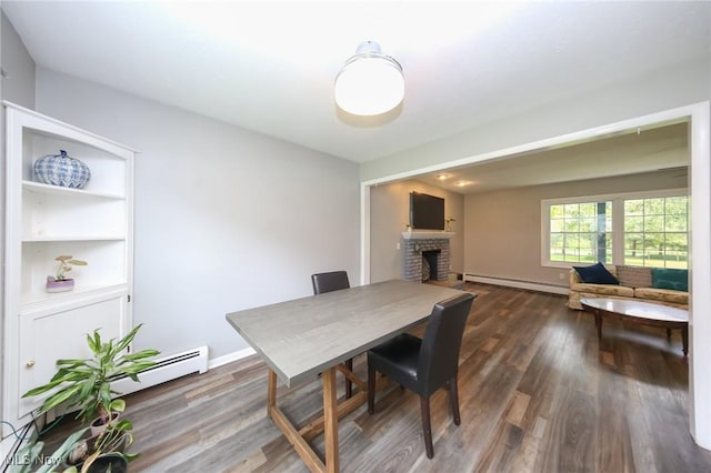 12274 Kile Rd, Chardon, OH 44024 - dining area featuring a baseboard heating unit, a brick fireplace, a baseboard radiator, and dark wood-style flooring