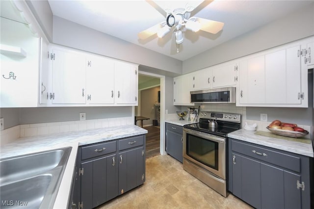 12274 Kile Rd, Chardon, OH 44024 - kitchen featuring stainless steel appliances, white cabinets, light countertops, ceiling fan, and gray cabinetry