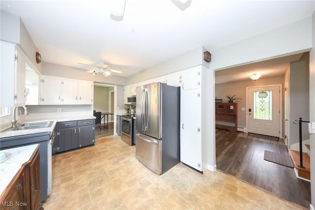 12274 Kile Rd, Chardon, OH 44024 - kitchen featuring appliances with stainless steel finishes, ceiling fan, white cabinets, light countertops, and a baseboard heating unit