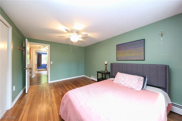 12274 Kile Rd, Chardon, OH 44024 - bedroom with baseboard heating, wood finished floors, and a ceiling fan