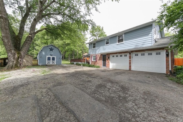 12274 Kile Rd, Chardon, OH 44024 - view of front of home with a storage shed, brick siding, asphalt driveway, and a garage